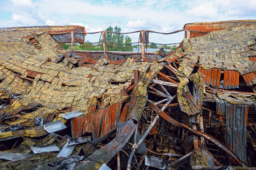 Destroyed industrial building. Insulated roof structures of an industrial building after fire and collapsing.