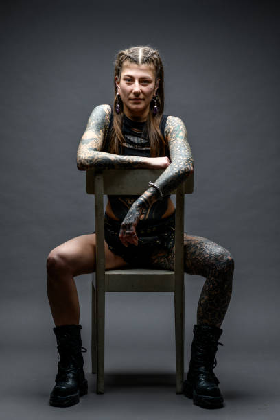 istock Tattooed girl studio portrait on gray background 1945181757