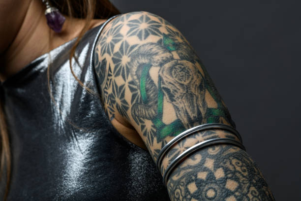 istock Tattooed girl studio portrait on gray background 1945188553