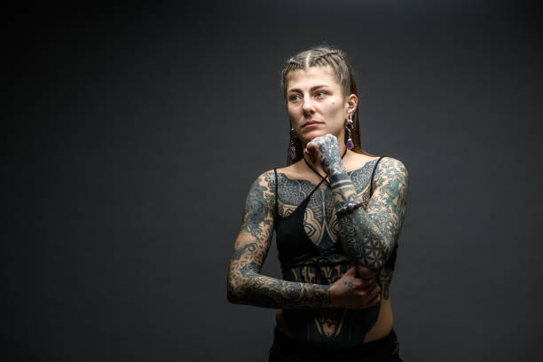 istock Tattooed girl studio portrait on gray background 1945192736