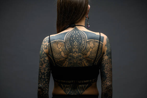istock Tattooed girl studio portrait on gray background 1945193254