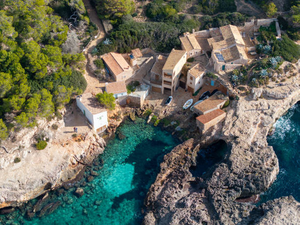 Europe, Spain, Balearic Islands, Mallorca, Santanyi, Cala Figuera . A small , colorful fishing harbor on S.E. corner of island. Sailboat anchoring.
