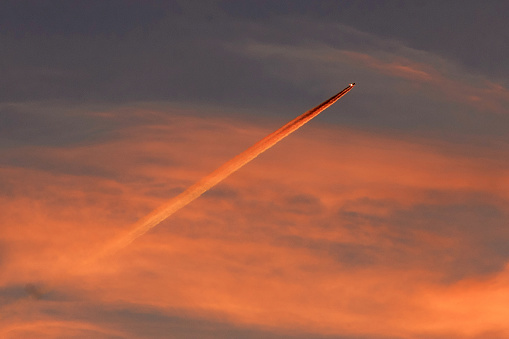 Evening orange sky with flying airplane