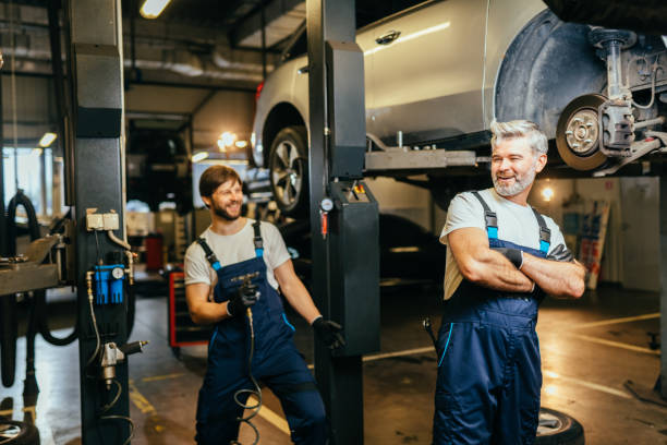 istock Funny mechanical engineering joking in car repair shop or garage. Workflow in a car workshop. Father working with his son. Family business concept. 1945222905
