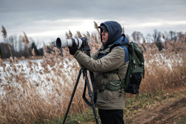 istock Photographer is setting up camera on tripod outdoors 1945223468