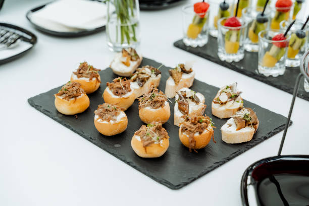 istock Catering, serving sandwiches on a stone board, cold cuts buns, breakfast in the office, takeaway, festive table, buffet meal. 1945229790
