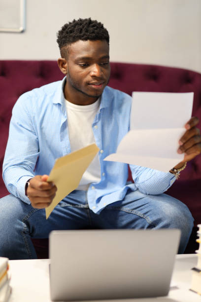 istock Focused businessman, working with paperwork and a laptop at home, exemplifying modern professional lifestyle and success. 1945264374