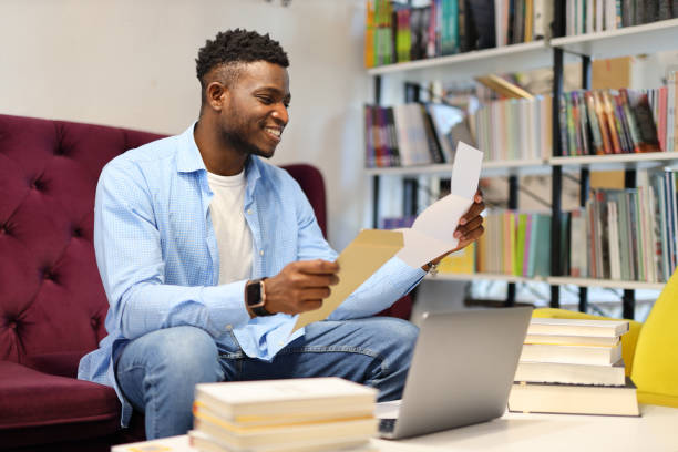 istock Young businessman confidently working on a laptop, showcasing a modern professional lifestyle in a sleek office setting. 1945264380