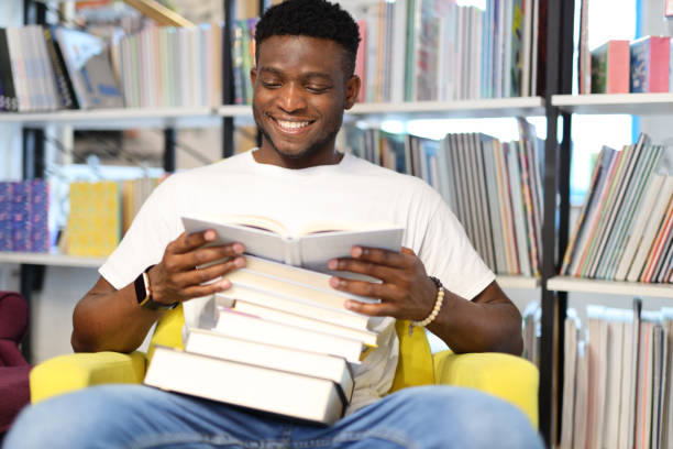 istock Serious young student engrossed in studying at a library, surrounded by books, embodying the pursuit of knowledge. 1945264386