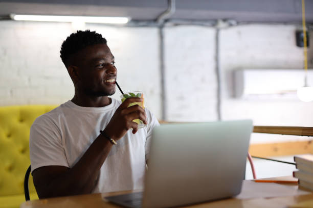 istock Happy young businessman using a laptop, exuding professionalism and happiness in a modern work or home setting. 1945264915