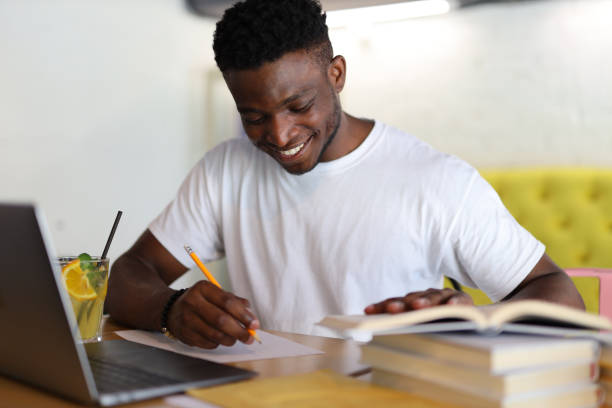 istock Focused student in a library, studying with a laptop and books, exemplifying dedication to education and academic pursuits. 1945264918