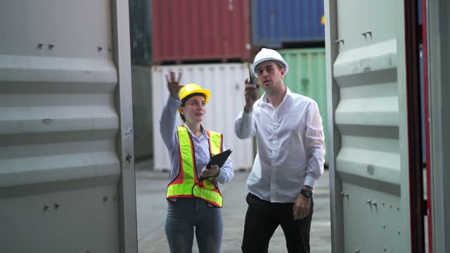 Male And Female Port Workers Opening Shipping Cargo Container