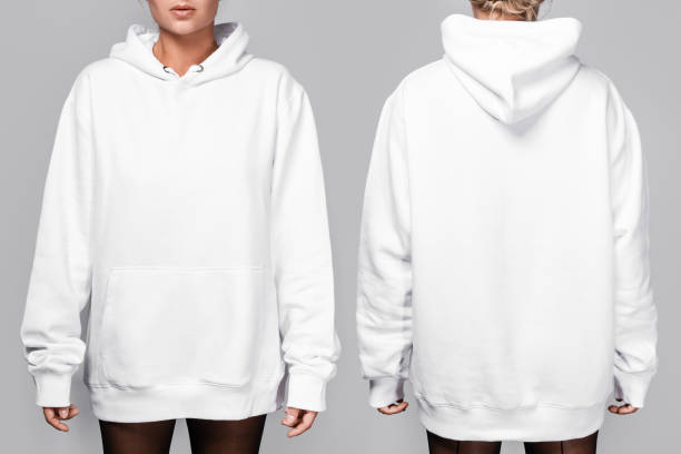 Front and back views of a woman wearing a white, oversized hoodie with blank space, ideal for a mockup, set against gray background Front and back views of a woman wearing a white, oversized hoodie with blank space, ideal for a mockup, set against gray background. hooded-shirt stock pictures, royalty-free photos & images