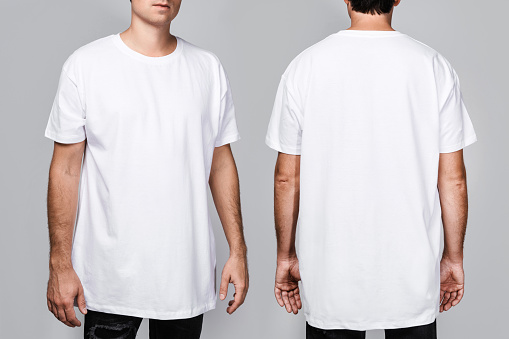 Front and back views of a man wearing a white, oversized t-shirt with blank space, ideal for a mockup, set against gray background.