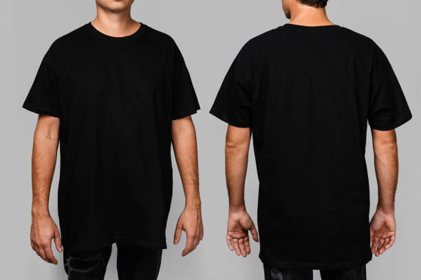 Front and back views of a man wearing a black, oversized t-shirt with blank space, ideal for a mockup, set against gray background Front and back views of a man wearing a black, oversized t-shirt with blank space, ideal for a mockup, set against gray background. shirt stock pictures, royalty-free photos & images
