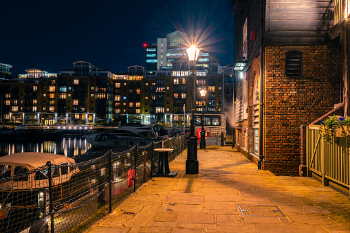 Empty street night scene at St Katharine Docks Marina in London