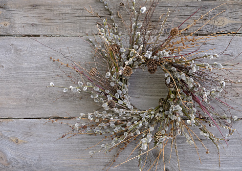 Easter wreath made of natural materials on a wooden background. Easter decor - a wreath on the door.