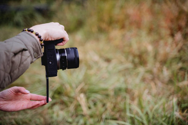 istock Digital camera in photographer's hands, hands holding camera, vertical shooting, flip-up camera screen, mirrorless camera. 1945323155