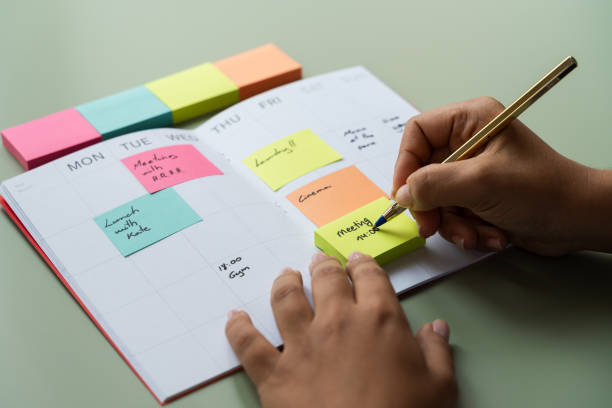 istock Person Writing on Notebook With Sticky Notes, Organized Workstation for Productivity Boost 1945362043
