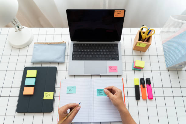 istock Person Sitting at Desk With Laptop and Notebook 1945364140