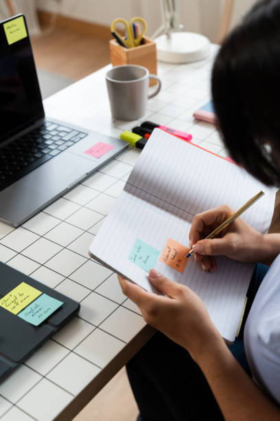 istock Person Working at Desk With Laptop and Notebook 1945367304
