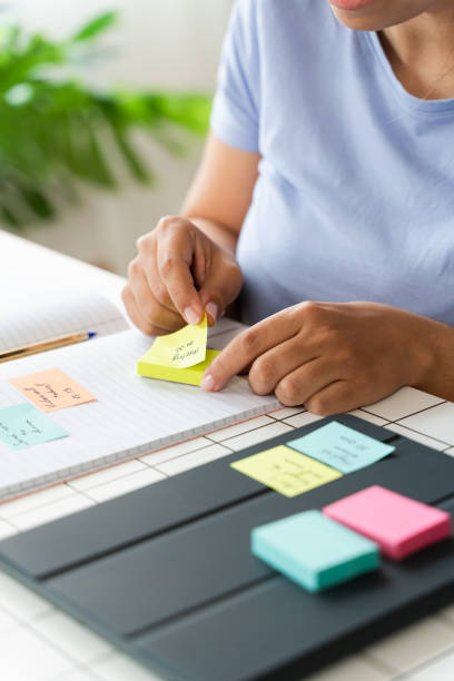istock Woman Sitting at Table With Sticky Notes for Organizing Tasks and Ideas 1945369881