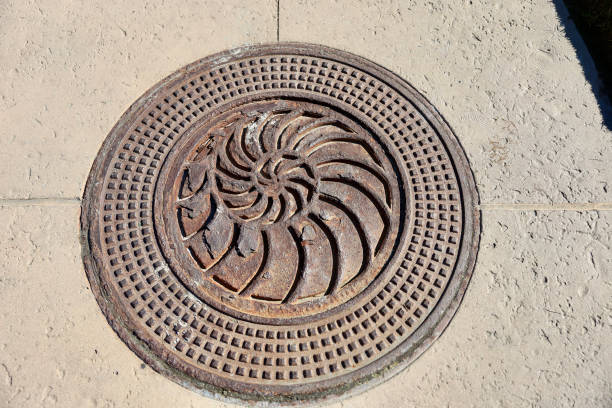 istock Vintage rusty manhole cover with nautilus design 1945393722