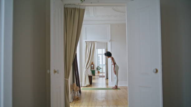 istock Yoga model training domestic interior. African girl doing flexibility exercises 1945406775