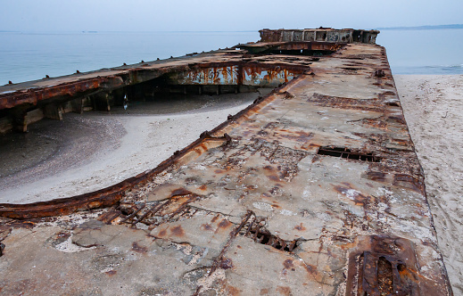 Old destroyed concrete barge abandoned on the sandy Kinburn Spit, Ukraine