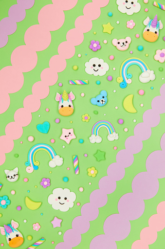 Trendy pastel green kawaii flyer background design template with cute air plasticine handmade cartoon animals, unicorns, stars, rainbows pattern. Top view, flat lay. Candycore, fairycore.