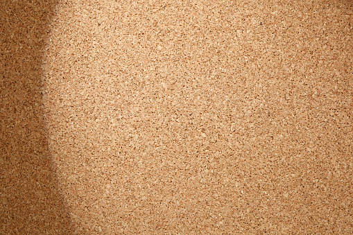 Brown color of cork board with circle light and shadow. Textured wooden background. Cork board with copy space. Notice board or bulletin board image.