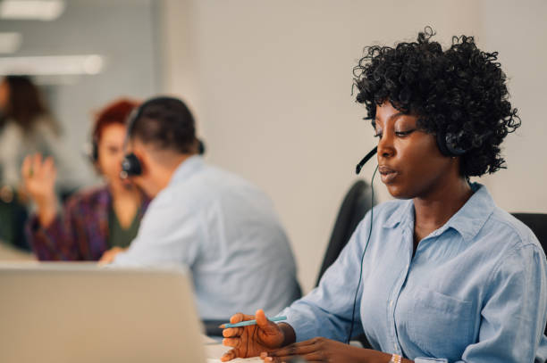 istock African american woman with headset working in an office and using a laptop 1945498983