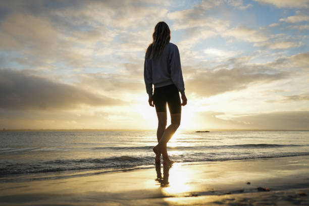 istock Beautiful Slim Woman walking at beach during sunset 1945508955