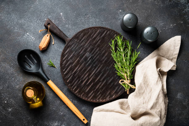 istock Spices and herbs with craft cutting board at black background. 1945535785