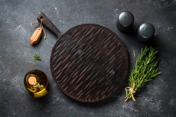 istock Spices and herbs with craft cutting board at black background. 1945535786