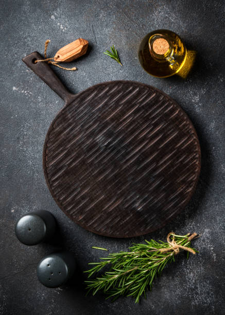 istock Spices and herbs with craft cutting board at black background. 1945535789