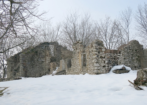 dilapidated house destroyed by earthquake and bad weather with snow on the hill in winter