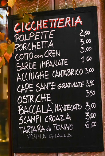 CICCHETTERIA means Snack bar in Italian and list of Italian cuisine foods meaning meatballs porchetta breaded sardines anchovies oysters cod and other dishes