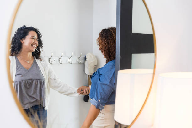 istock Mirror reflects two female friends talking in front entry 1945606249