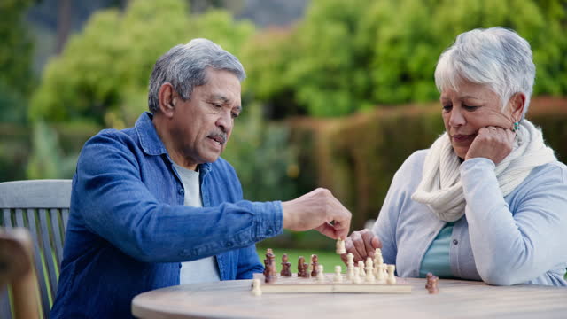 Senior man, woman and chess in park for competition, contest or problem solving at table in nature. Couple, retirement or vintage board game for challenge, decision or thinking for strategy in garden