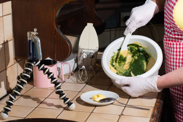 istock woman cooking spinach muffins step by step, mixing ingredients with spatula 1945623825