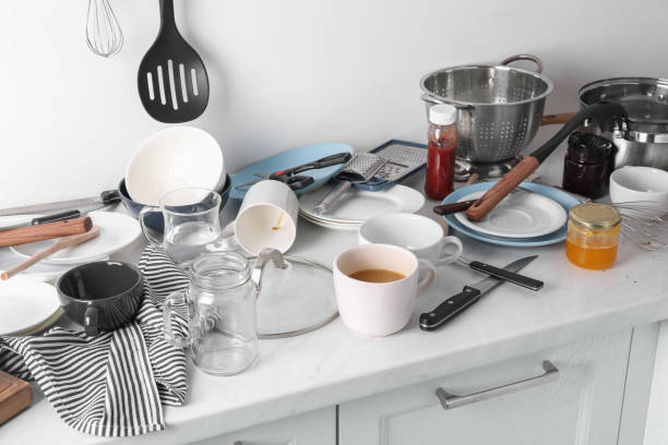 istock Many dirty utensils and dishware on countertop in messy kitchen 1945649818