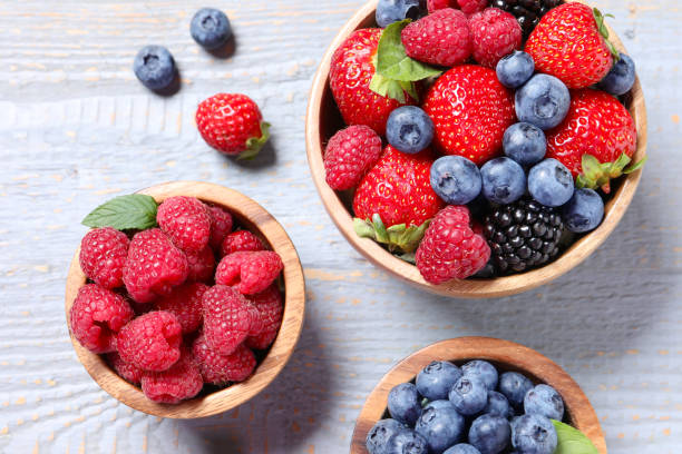 istock Different fresh ripe berries on light grey wooden table, flat lay 1945651393