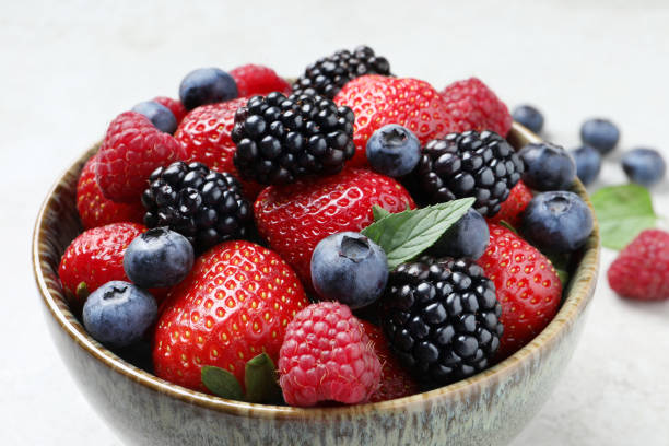 istock Different fresh ripe berries in bowl on table, closeup 1945651921