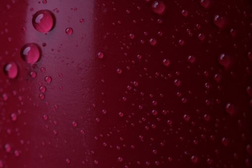 Texture of red lipstick with water drops as background, macro view