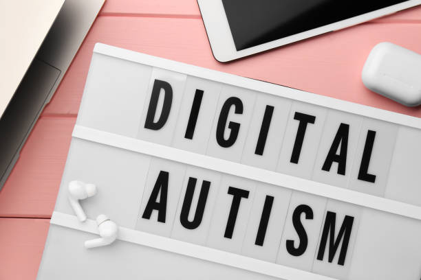istock Lightbox with phrase Digital Autism and devices on pink wooden table, flat lay 1945707489