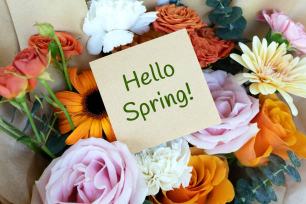 istock Hello Spring text on adhesive note and bunch of flowers bouquet 1945708022