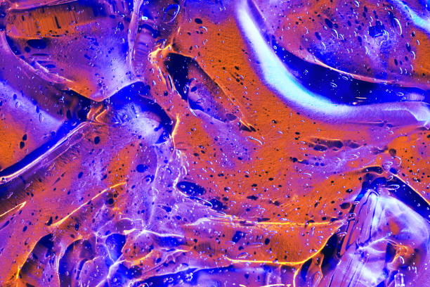 istock Abstract neon blue, purple, red, orange cosmetic gel serum background texture 1945732990