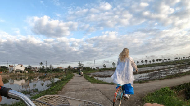 istock Mature couple ride bicycles through rice paddies 1945737168