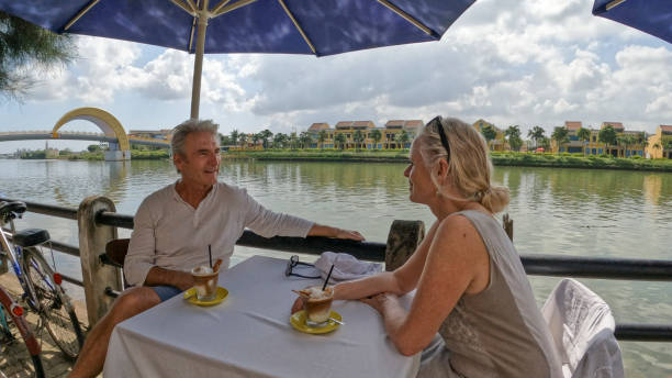 istock Mature couple enjoy beverage at outdoor cafe 1945743218